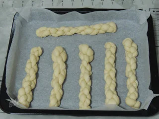 砂糖麻花面包,依次做好所有的麻花面团,摆放到烤盘中,中间留出发酵的空间。