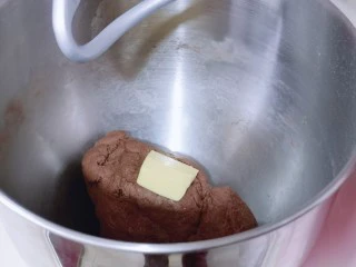 懒人必做~巧克力贝果,这时面团处于扩展阶段。加入室温软化的黄油,启动厨师机2档揉面15-20分钟,揉到有了不容易破的手套膜即可。