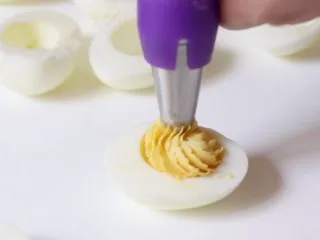 绿色美食+鱼子酱魔鬼蛋,将蛋黄混合物挤入蛋白窝内。