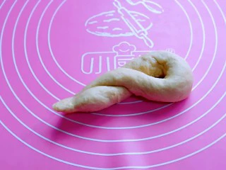 松软老式小面包,将两头相接，左手固定顶部的中间，扭两圈，将相接的处塞进圆圈里，收口捏紧。
