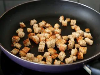 西红柿土豆浓汤,6.锅里倒少量的油,油热下面包小方丁,用中小火焙炒到焦黄,盛出待用。