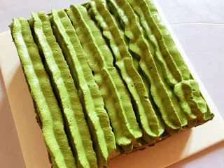 红豆抹茶巧克力慕斯,把冻过的慕斯取出，去掉围边后，用刀切掉四周的蛋糕边角料让四个边平整，再用花嘴挤上奶油装饰即可。