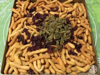 蔓越梅沙琪玛,放入蔓越梅和葡萄干,翻拌均匀。