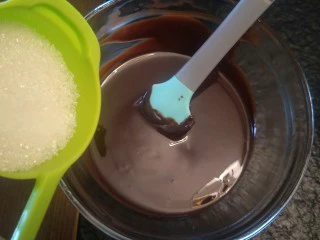 来自冬天的温暖—重芝士布朗尼蛋糕,从热水碗中拿出加入40克糖。搅拌均匀。