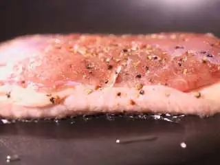 法式香橙煎鸭胸 ,中火烧热锅中的油,放入鸭胸,带皮面朝下,煎1~2分钟至两面上色。