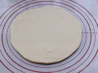 海虾杂蔬披萨,静置松弛好的面团,用擀面杖擀成圆形薄面皮。