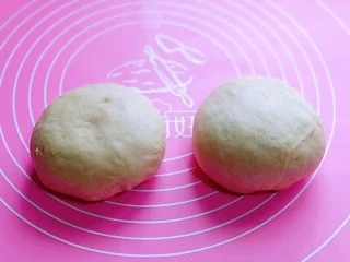 沙拉火腿面包卷,发酵好的面团分成2份，盖上保鲜膜松弛10分钟。