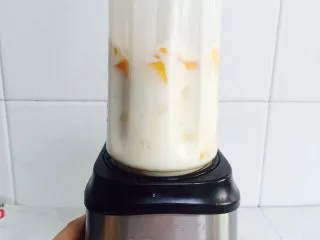 芒果香蕉奶昔,倒扣在果汁机上拧紧，摁启动键开始工作。