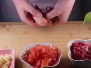教你一个拌面的新吃法，口感爽滑劲道,首先将所有食材准备后，我们先将大蒜剁成蒜末、牛肉剁成牛肉糜、取半个番茄切成番茄丁、火腿肠壳后备用。
