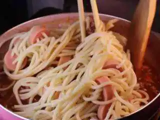 教你一个拌面的新吃法，口感爽滑劲道,借助筷子和铲子将意面拌匀。