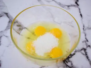 巧克力蛋糕甜甜圈,鸡蛋打入盆中,加入全部的白糖