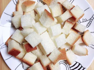 鸡蛋牛奶布丁,先将切片面包切成小块。