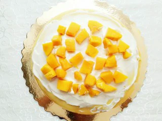 榴芒千层蛋糕,放上芒果粒!就按照这个顺序,一层榴莲奶油,一层芒果奶油,直至把所有皮子用完!