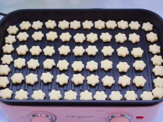 奶香小花朵馒头,把小花朵面胚，全部均匀的码放在平底锅里。