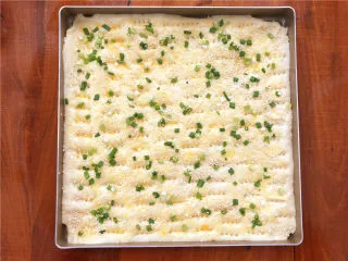 香葱肉松面包卷,刷上一层蛋液（揉面团用剩下的蛋液），撒上芝麻和香葱。 