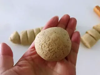 黑豆渣窝窝头,取一个面剂子,慢慢搓成圆形。