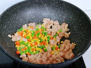 披萨新吃法~奥尔良鸡丁披萨,待鸡肉炒至变色后,加入玉米粒,豌豆,胡萝卜丁,小火翻炒,加入一小勺纯净水,中小火煮3-5分钟,将食材煮熟即可。