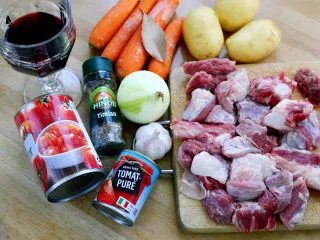 #食二星座#法式红酒炖牛肉 Boeuf Bourguignon,1.材料图： 牛肉、番茄膏、罐装番茄碎、洋葱、大蒜、香叶、百里香、红酒、胡萝卜、土豆 注：以上材料是最基础的，香料类还可用欧芹，配菜里还可以加入口蘑、培根等。