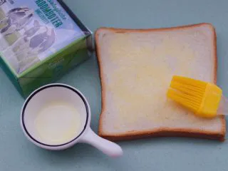 田园时蔬吐司披萨,把融化好的黄油，用刷子把黄油刷到吐司片上。