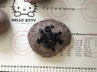 黑加仑黑米软欧包,12、放入黑加仑葡萄干。(黑加仑葡萄干提前用温水泡软后沥干水分）