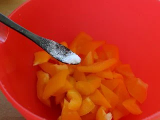 苹果柠香烤鸡腿,在烤的同时，我们将甜椒洗净、切成大块，调点盐。 