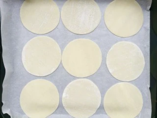 饺子皮辣酱饼,饺子皮平铺在铺上油纸的烤盘上。