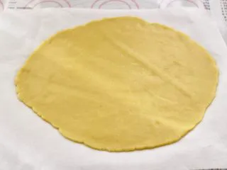 KT黄油蛋黄饼干,把面团用擀面杖擀成薄片,用油纸包好,放入冰箱冷藏30分钟。