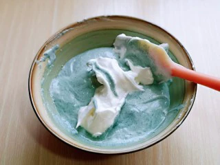 6寸蝶豆花戚风蛋糕,再取三分之一的蛋白霜加入蛋黄糊中,继续上面的手法,翻拌直至看不到蛋白霜。