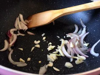 西餐之黑椒鸡丝意大利面,将大蒜去皮洗净切碎放入锅中爆香