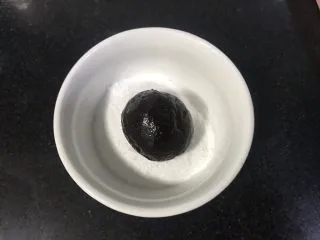 裂纹巧克力软饼干,放入糖粉碗里,滚圆沾满糖粉。