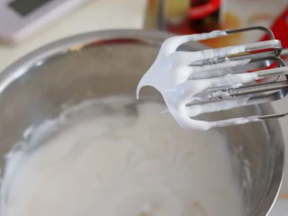 火爆Ins的StrawberryOmelet草莓抱抱卷,蛋白中滴入柠檬汁,倒入细砂糖,打至中性发泡。