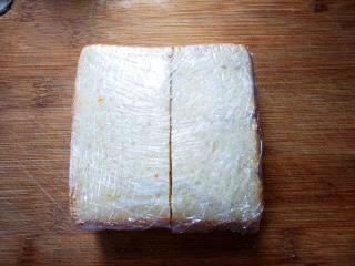 紫薯肉松三明治,裹上保鲜膜，尽量压紧实一些再切哦~