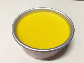 百香果冻芝士蛋糕,提前用冷水泡软7克吉利丁片,在容器内加入所有镜面材料,隔水融化后冷却至室温,倒在芝士蛋糕表面,继续冷藏2小时