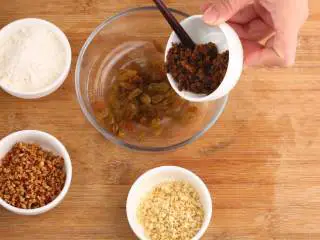 中式点心红糖夹心馒头,将葡萄干、腰果碎、红枣碎和刚才预留的红糖、面粉倒在一起,混合搅拌均匀