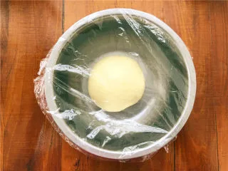 香葱肉松面包卷,揉至能轻松拉出手套膜，把面团重新整好，盖上保鲜膜，放置在温暖处发酵。 