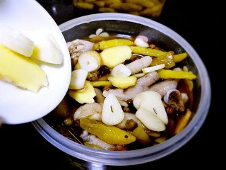 ~泡椒凤爪~,将鸡爪放入密封盒，倒入调味汁，加入蒜片、姜片。 泡椒水是咸的，如果不够需要加盐，稍微咸一点儿鸡爪才够味。