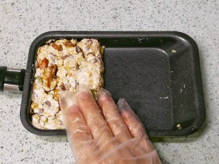 果仁燕麦能量棒,离火，由于FLUFF棉花糖本身就是液态，因此加热时间不长，温度不会太高，可以直接用手（戴手套）在锅里把果仁燕麦按紧整形，压成厚片，晾凉。
