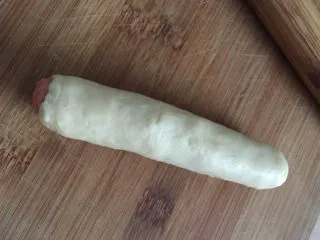 这样吃披萨才爽——重芝士火腿边披萨,各取30g面团擀成薄片将火腿放入卷起收口按实，三根如此卷好切小段备用，再取30g面团用同样手法将奶酪放入卷起切段备用