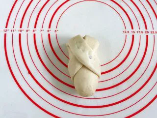 牛奶炼乳蔓越莓软欧,然后将左边的那条继续往面团右下方折,在底部将接口处捏紧。