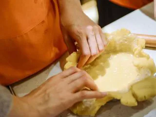 #春日烘焙教室#草莓塔/水果塔,整形入模具:塔皮从冰箱取出，用擀面杖擀开，把塔皮装入模具中，切除多余的面皮。用叉子把皮叉出洞，防止烤的时候膨胀。