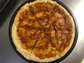 秘制芝心卷边披萨,烤好的饼皮切成6-8块儿，抹上适量的自制披萨酱。