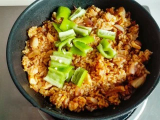 什锦咖喱焗饭,咖喱粉完全炒匀后，加入切好的青椒。炒匀关火。