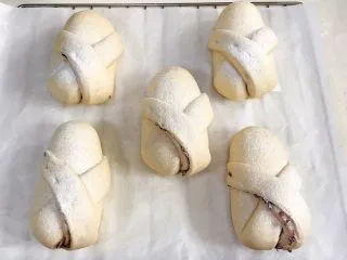 牛奶炼乳蔓越莓软欧,面团发至两倍大时取出,筛上一层薄薄的高筋面粉。