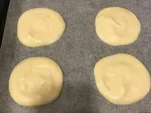 韩式—草莓蛋糕卷,烤盘上放烘焙纸⋯在烘焙纸上,挤出4个小圆麵糊⋯挤的时候,由中心往外画,不要太薄哦,尽量挤均匀。