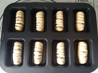 香葱火腿面包卷,待全部做好后放入模具中，送至烤箱再加碗热水发酵至2倍大