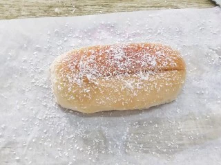 椰蓉奶油面包,把面包中间划一刀,再刷上一层溶化的黄油,撒上椰蓉