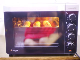 西兰花肉松芝士饭团,放入预热好的烤箱，200度上下火中层烤6分钟。