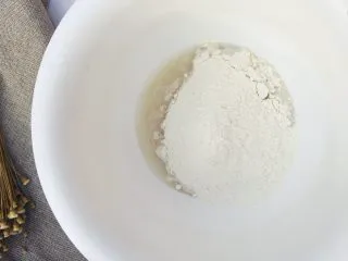 当主食一次可以吃三个的法棍面包,将混合均匀的粉类倒入溶解的酵母水里,倒入一半左右。