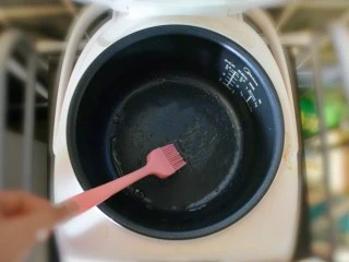 奶香葡萄干小面包（电饭锅版）,将电饭锅的底部和侧面，用刷子刷一层油。