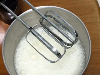 咖啡玉枕蛋糕,鸡蛋分离出蛋白和蛋黄，蛋白中加入柠檬汁，用打蛋器高速搅打30圈，加入30克细砂糖。